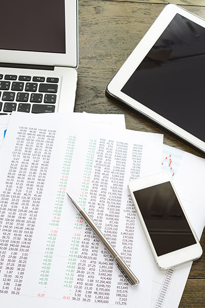 Ordinateur portable, tablette, smartphone et tasse à café avec des documents financiers